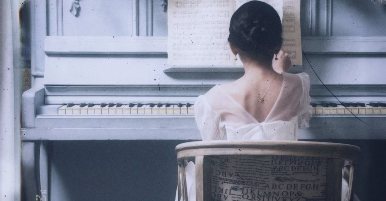 Note-Taking - A woman sitting at a piano with flowers on the wall