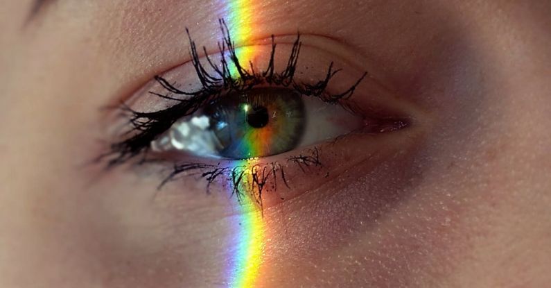 Mind Maps - Closeup of crop anonymous sad female with green eyes and rainbow light on face looking at camera