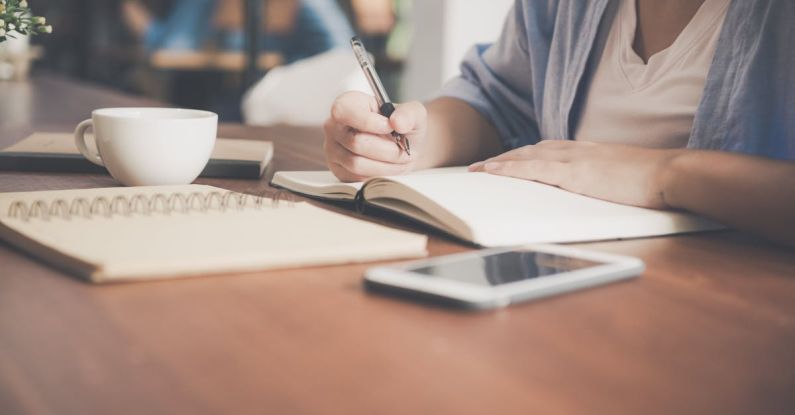 Social-Emotional Learning - Woman Writing on a Notebook Beside Teacup and Tablet Computer