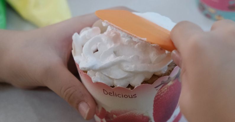 SAT Preparation - A child is making a cupcake with icing