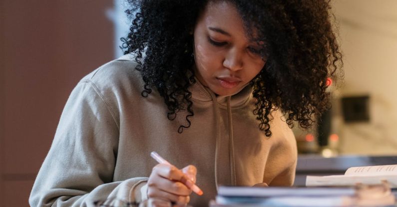 GRE Exams - Girl Sitting at the Table with Textbooks and Studying